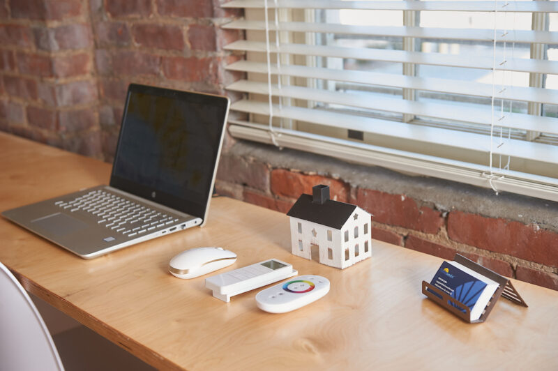 A wooden desk with a laptop and office controllers on top, installed for Thriveworks by Fraser Wood Elements in Fredericksburg, VA.