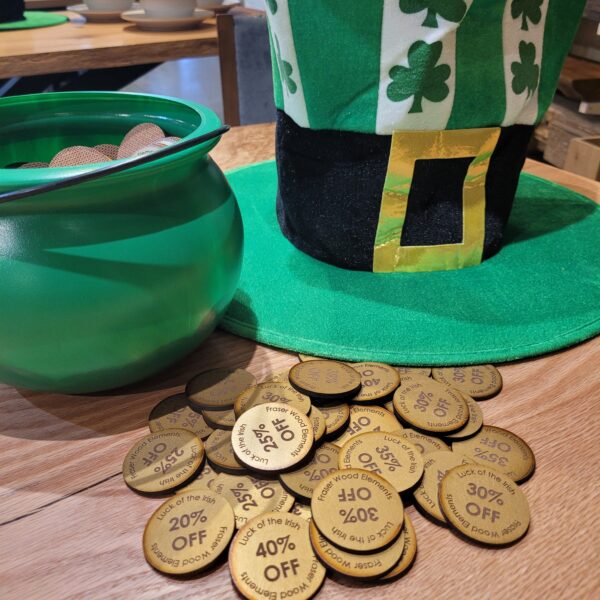 A closeup of a green leprechaun pot and hat, plus wooden "coins" that can be drawn for the lucky bucket sale promotion at Fraser Wood Elements in Fredericksburg, VA.